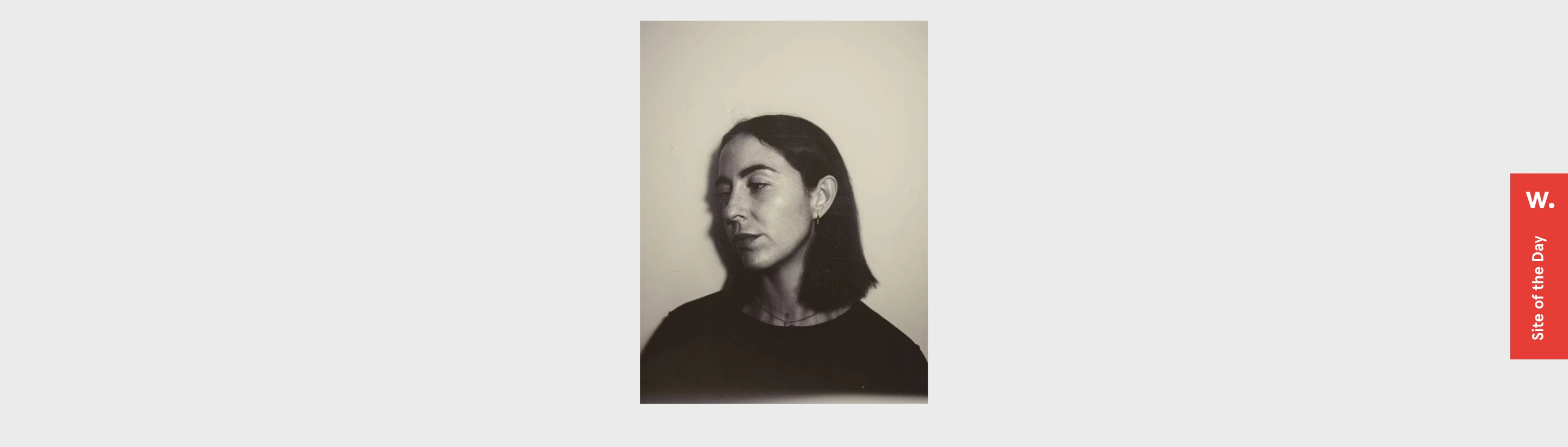 An intimate black-and-white photographic portrait floating in expansive, quiet pale grey space.