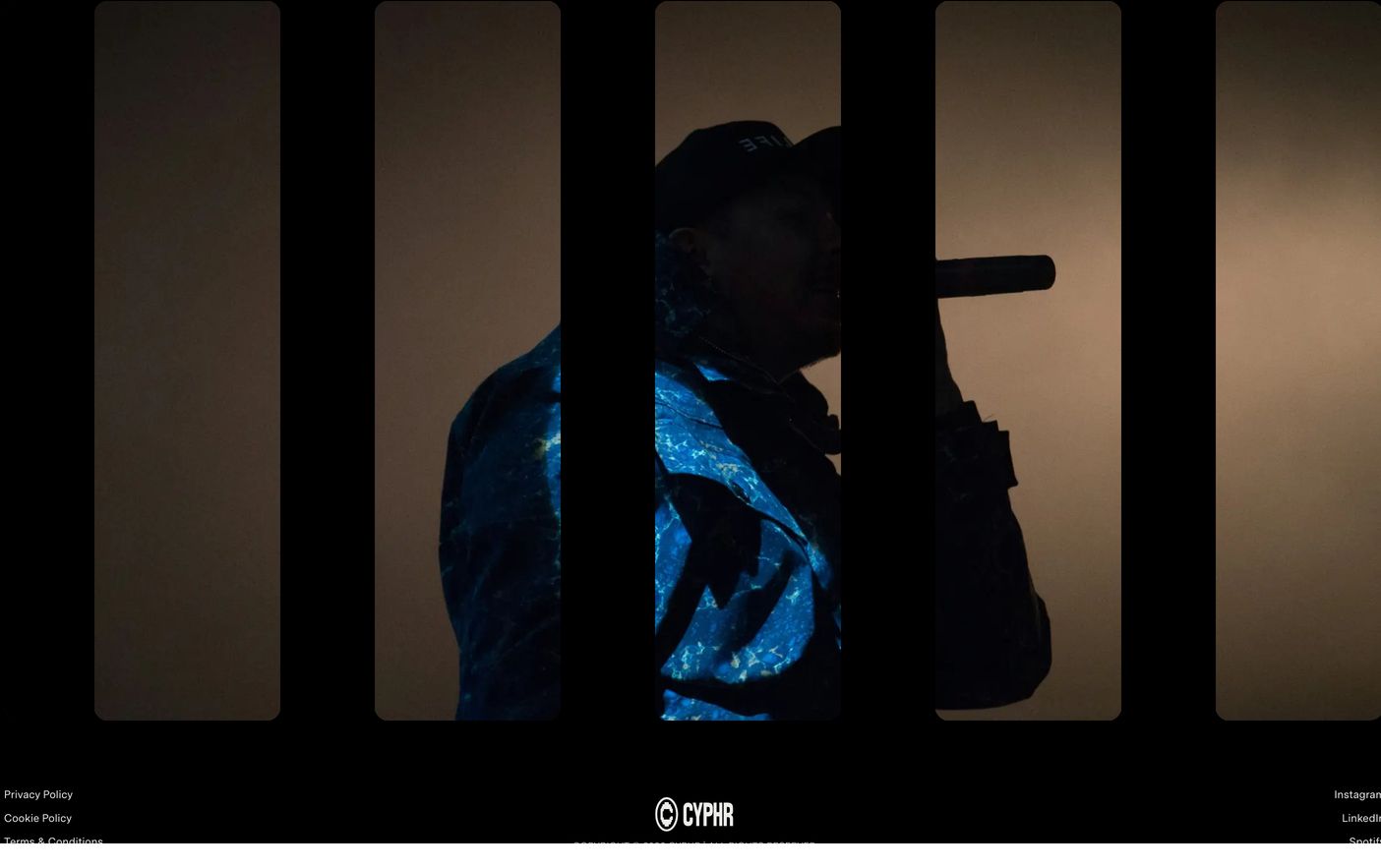 A moody, cinematic dark footer featuring a slatted vertical window revealing atmospheric concert photography above minimalist typographic links.