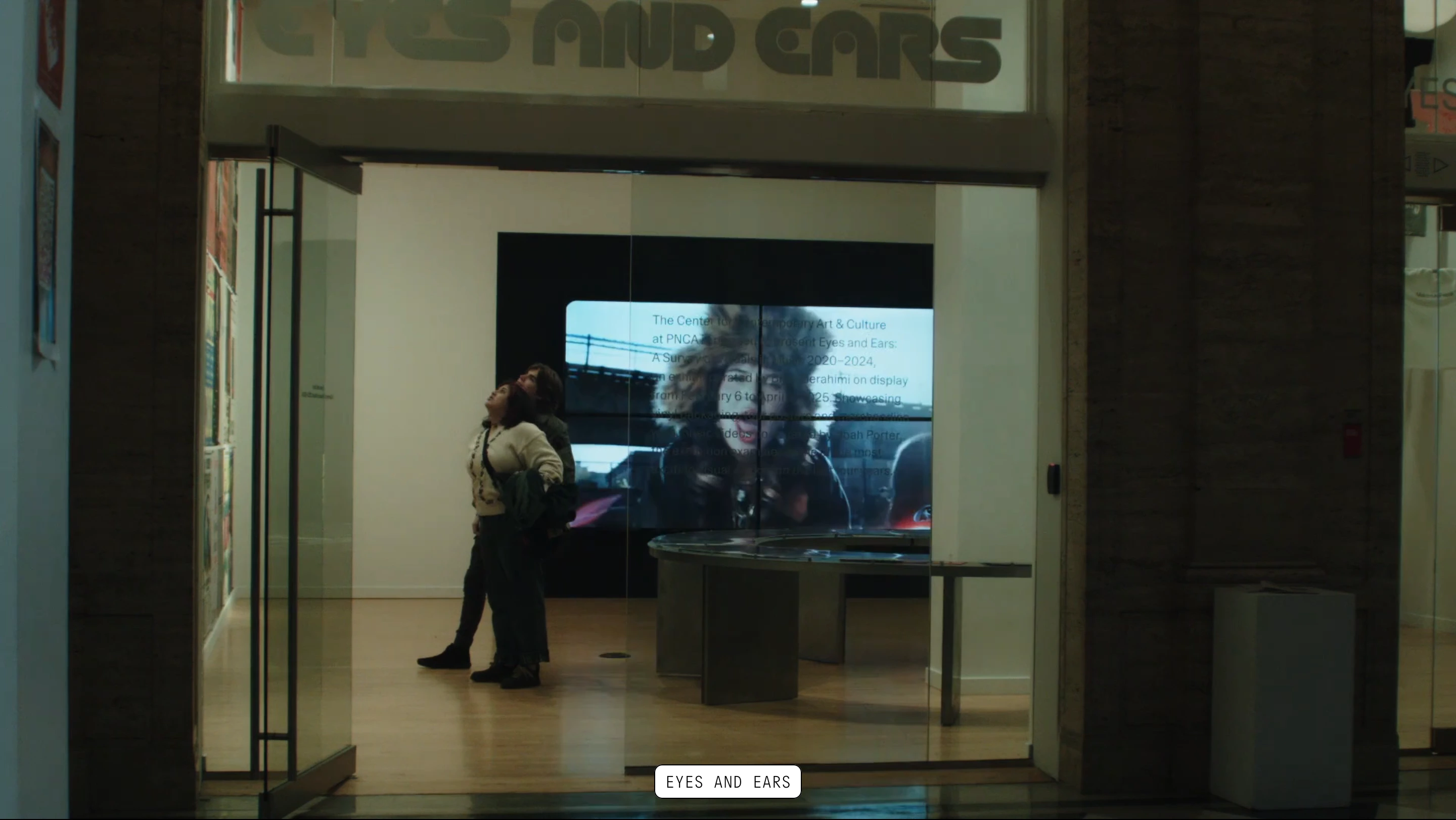 Atmospheric full-bleed exhibition video providing an immersive documentary view anchored by a minimal uppercase floating label.