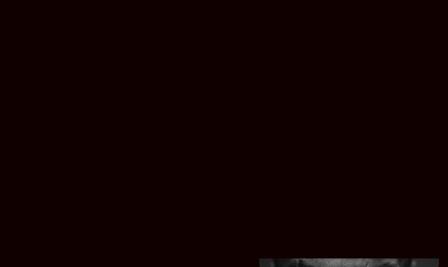A stark, shadowy dark void punctuated only by the top edge of a monochromatic visual at the base.