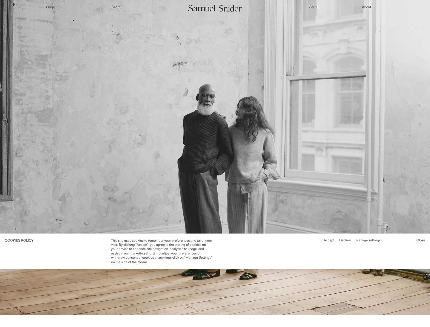 Quiet and deeply restrained editorial hero dominated by full-bleed black-and-white portraiture with delicate, widely spaced typography floating across the top edge.