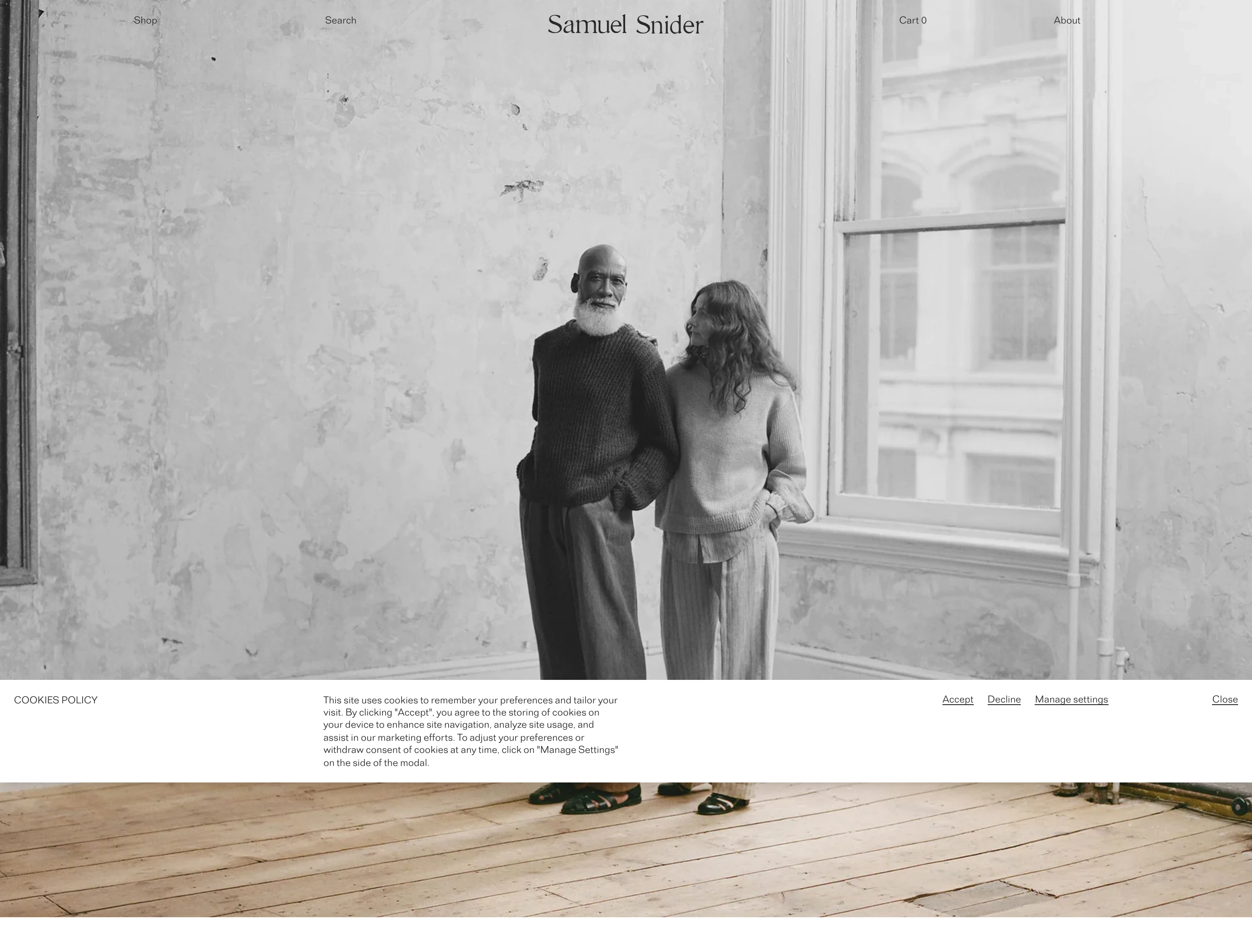 Quiet and deeply restrained editorial hero dominated by full-bleed black-and-white portraiture with delicate, widely spaced typography floating across the top edge.