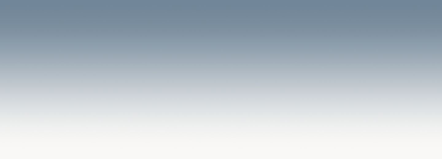 An empty, serene transitional gradient fading softly from a dusty slate blue into warm off-white.