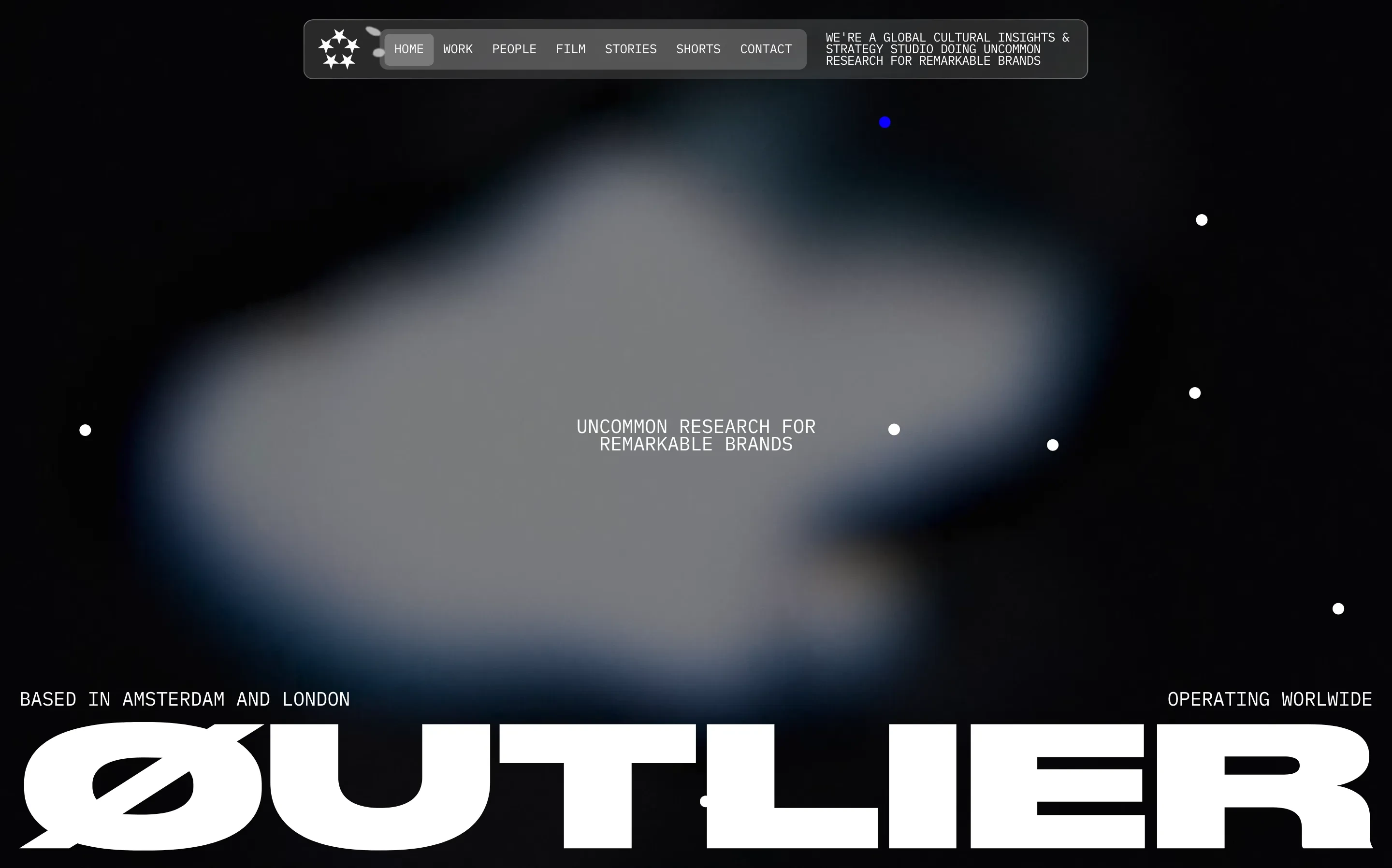 Dark, atmospheric hero with an ethereal glowing cloud backdrop, constellation-like pinpoints, and giant monolithic typography anchored at the base.