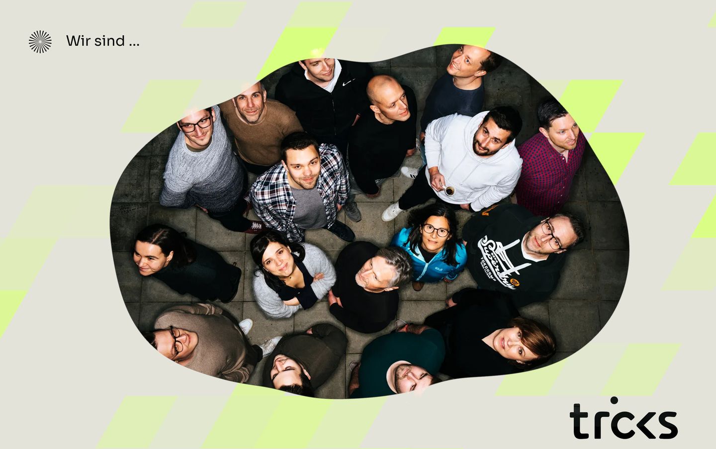 An overhead team portrait framed inside an organic cutout on a neutral canvas with neon geometric accents.
