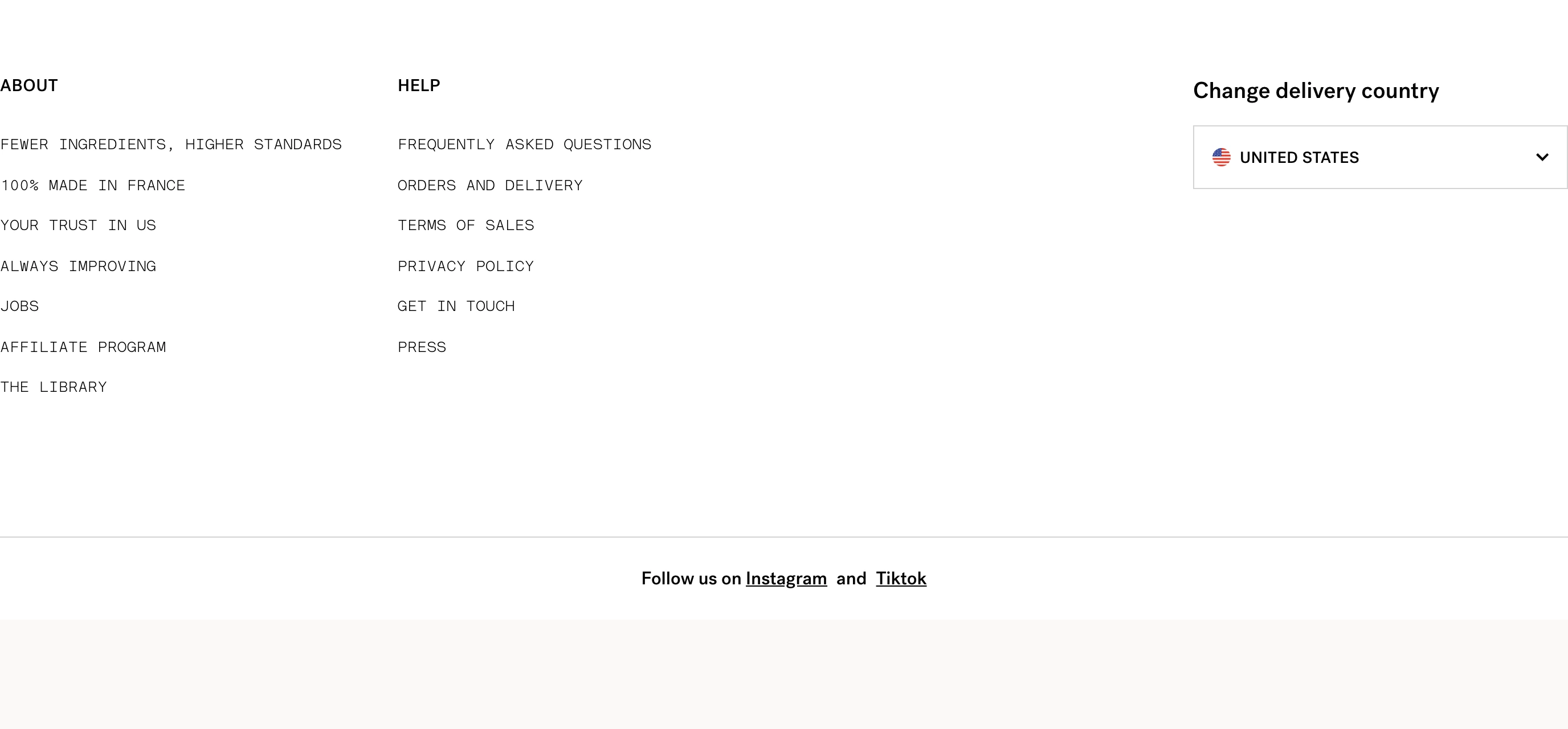 An airy, minimalist monochrome footer organized into sparse uppercase link columns and a country selector.