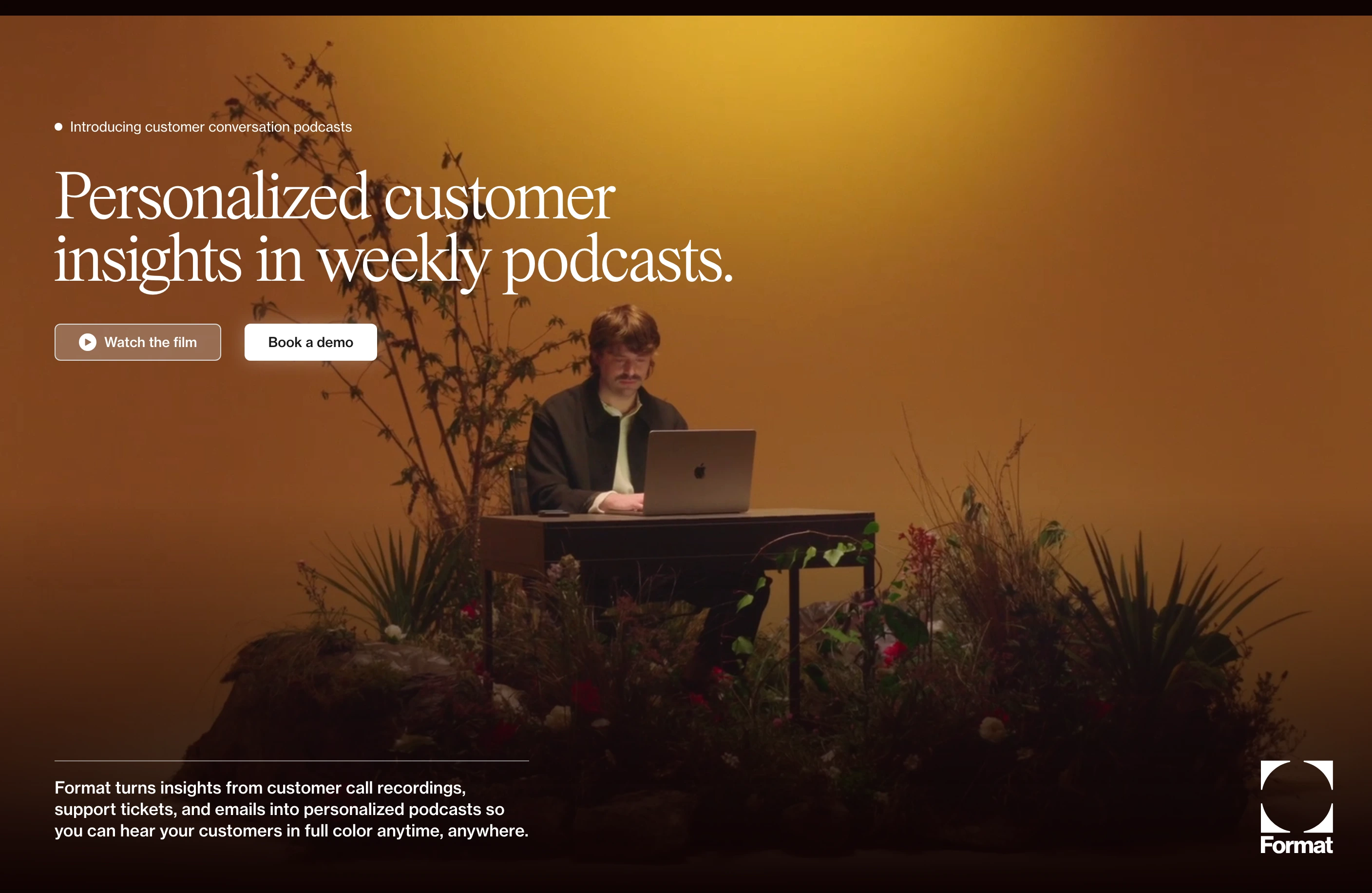 A cinematic golden-lit set creates an intimate, theatrical stage for an editorial tech hero with elegant serif typography.