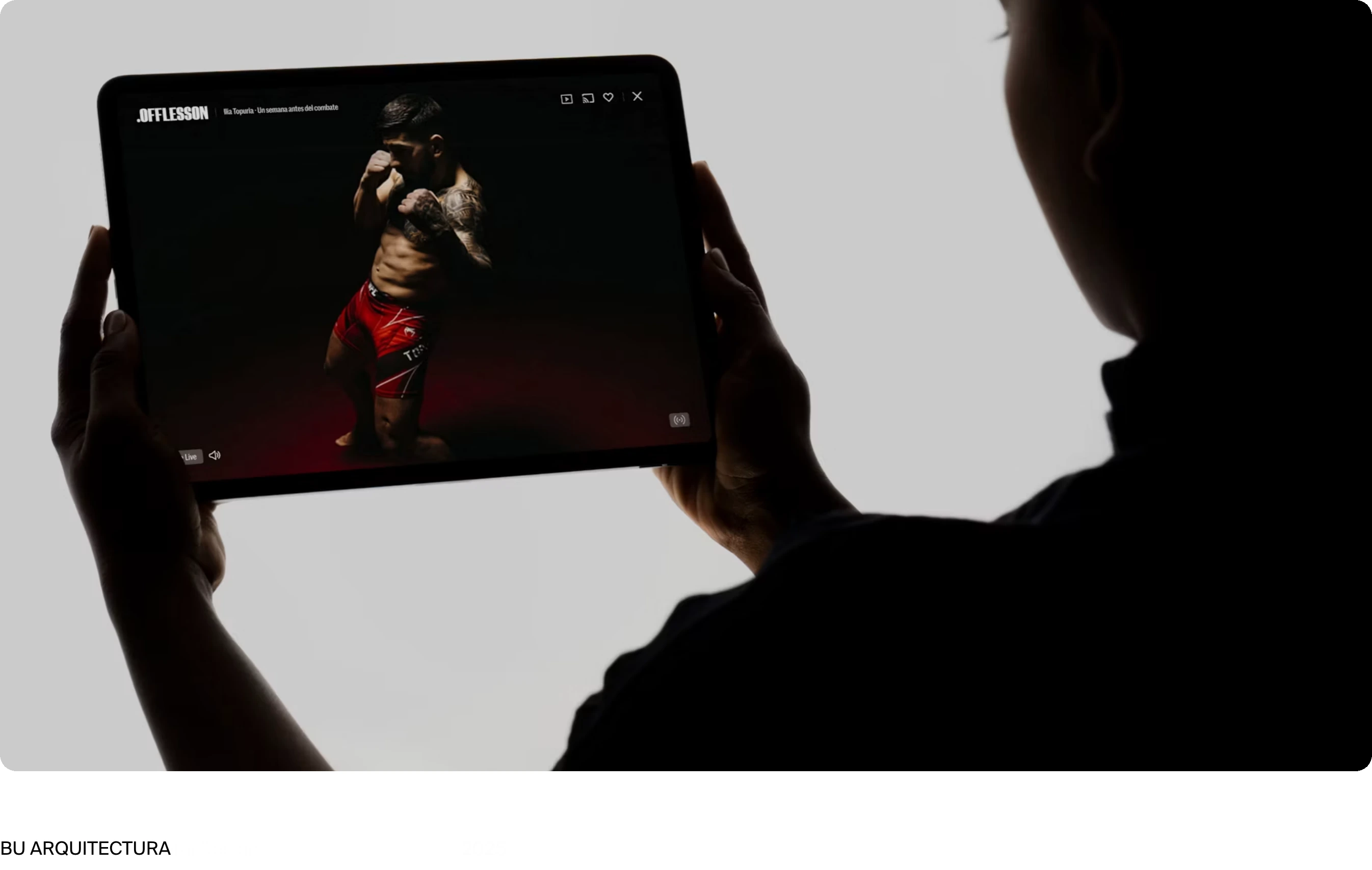 Dramatic chiaroscuro studio photography of hands holding a tablet showcasing digital video work in a stark minimal layout.