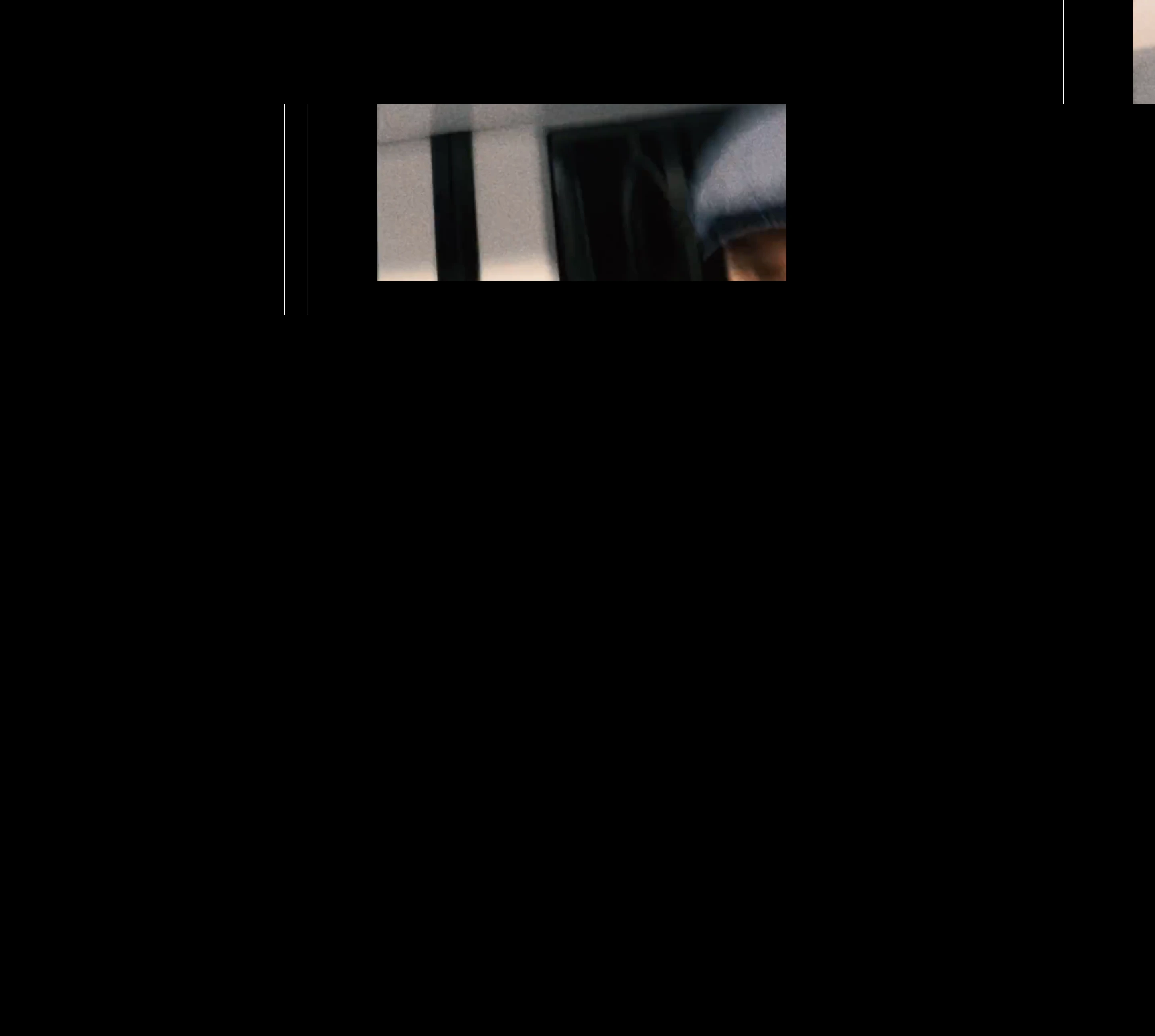 Cavernous black void framing a small, cropped cinematic sliver with stark vertical boundary lines.
